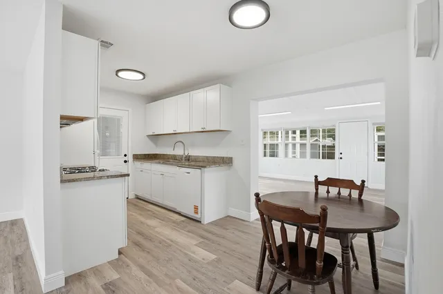 a kitchen with granite countertop white cabinets and stainless steel appliances