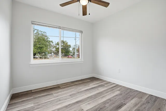 a view of an empty room with wooden floor