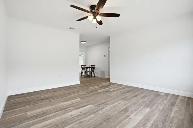 a view of empty room with wooden floor