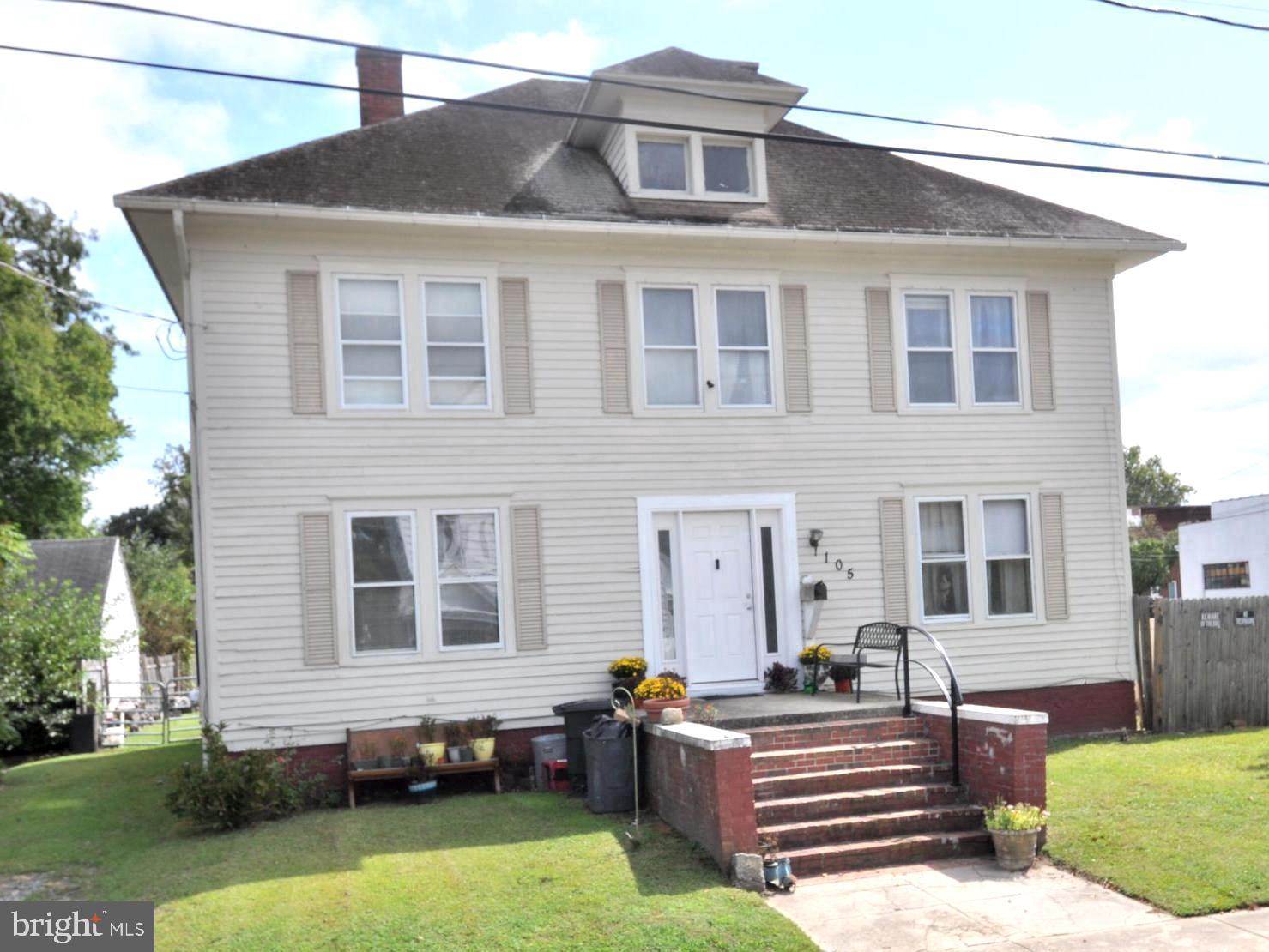 105 Front Street Pocomoke City, MD 21851 - Photo 1 of 50 a front view of a house with a yard table and chairs