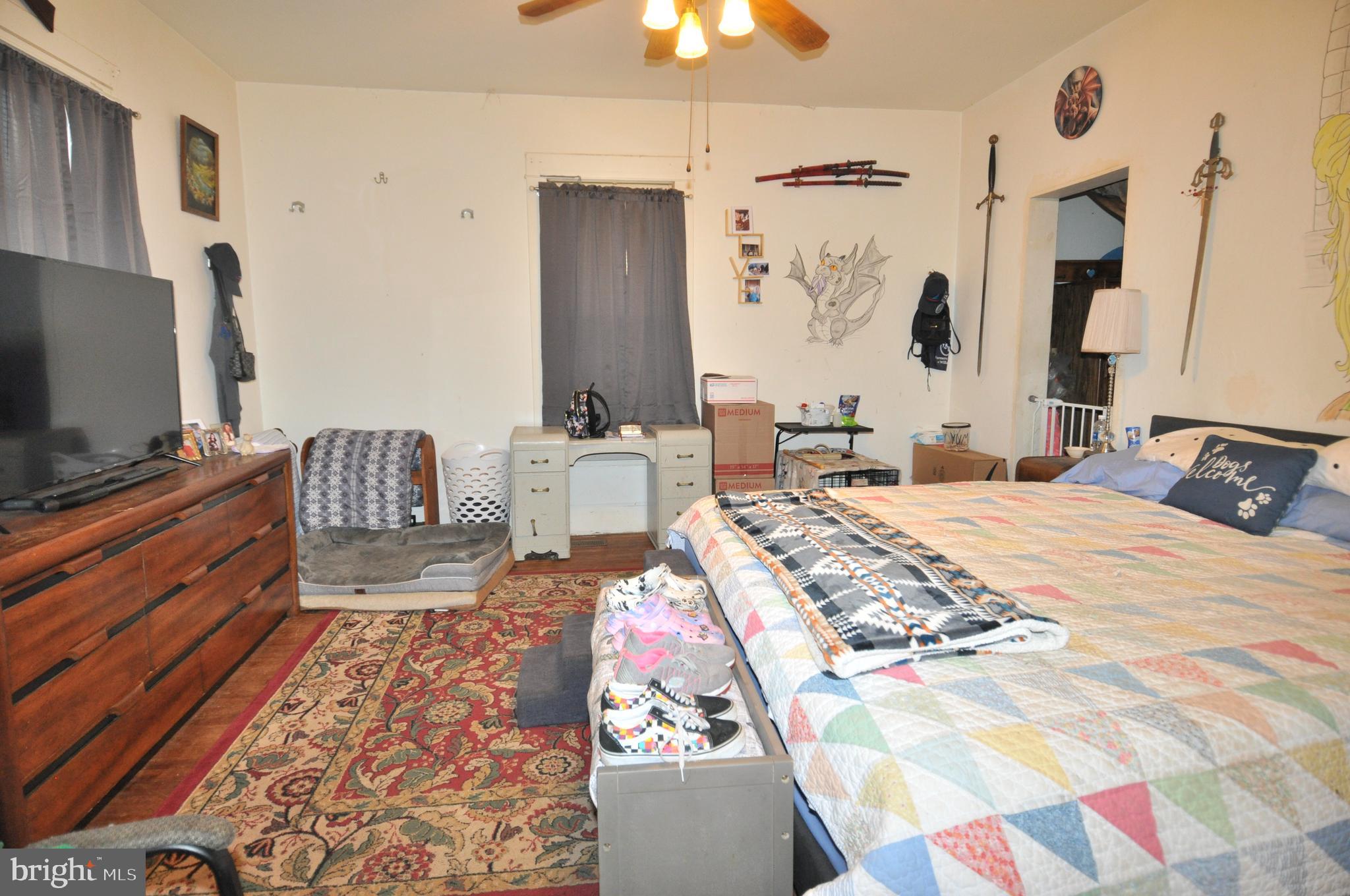 105 Front Street Pocomoke City, MD 21851 - Photo 21 of 50 a bedroom with a bed and a chandelier