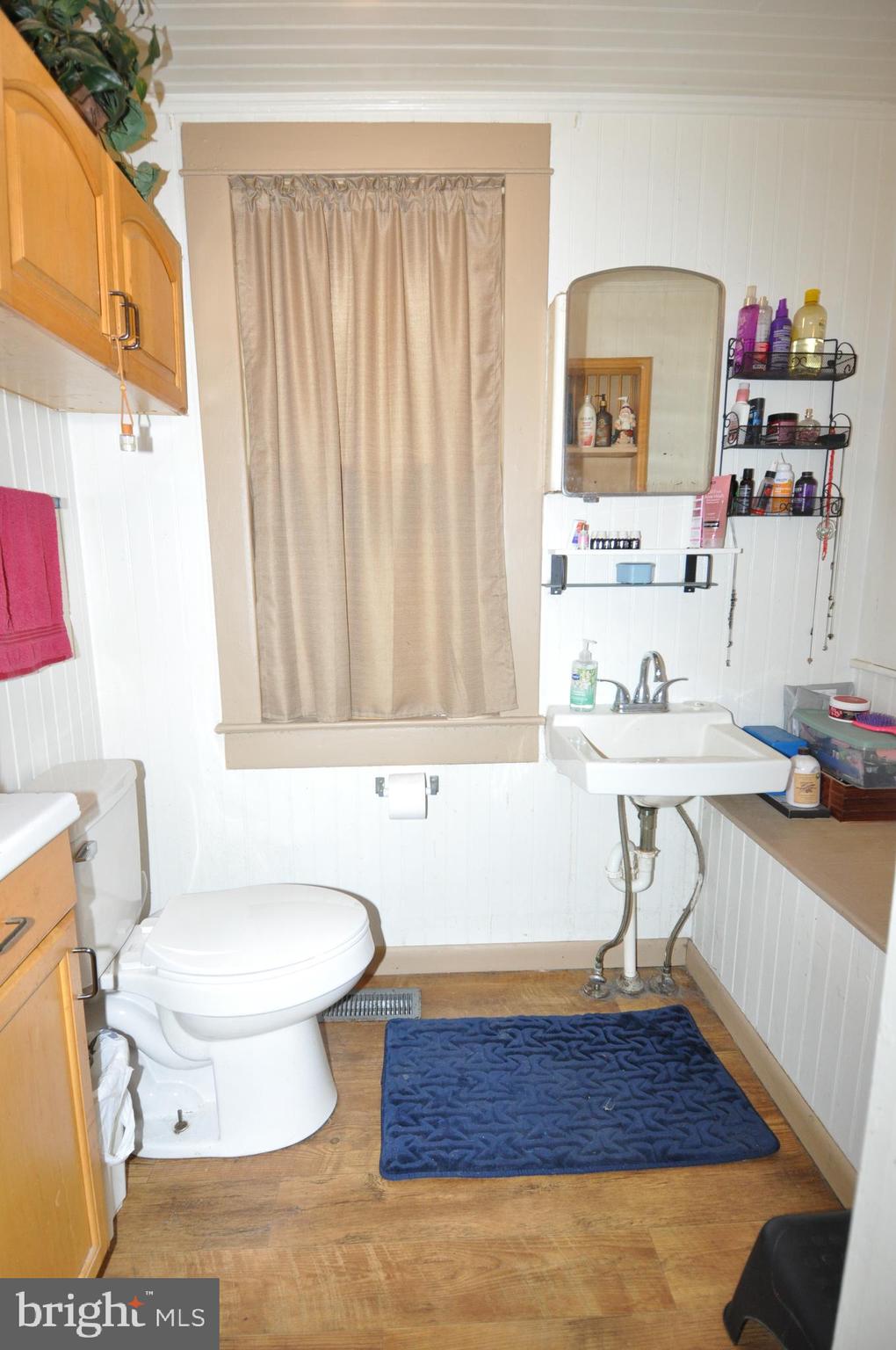 105 Front Street Pocomoke City, MD 21851 - Photo 41 of 50 a bathroom with a sink a toilet and a mirror
