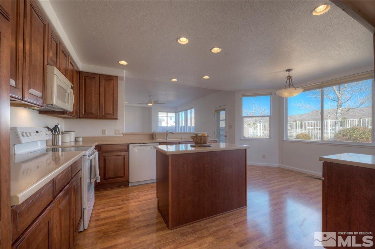 10016 Cascade Falls Drive Reno, NV 89521 - Photo 11 of 40 a kitchen with kitchen island granite countertop a sink cabinets and wooden floor