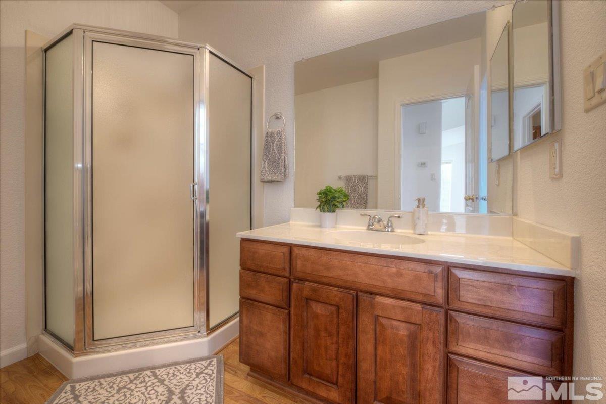 10016 Cascade Falls Drive Reno, NV 89521 - Photo 19 of 40 a bathroom with a granite countertop sink mirror and a shower