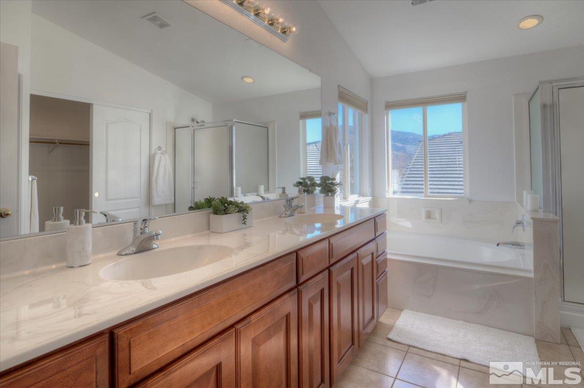 10016 Cascade Falls Drive Reno, NV 89521 - Photo 24 of 40 a bathroom with a granite countertop sink mirror and a bathtub