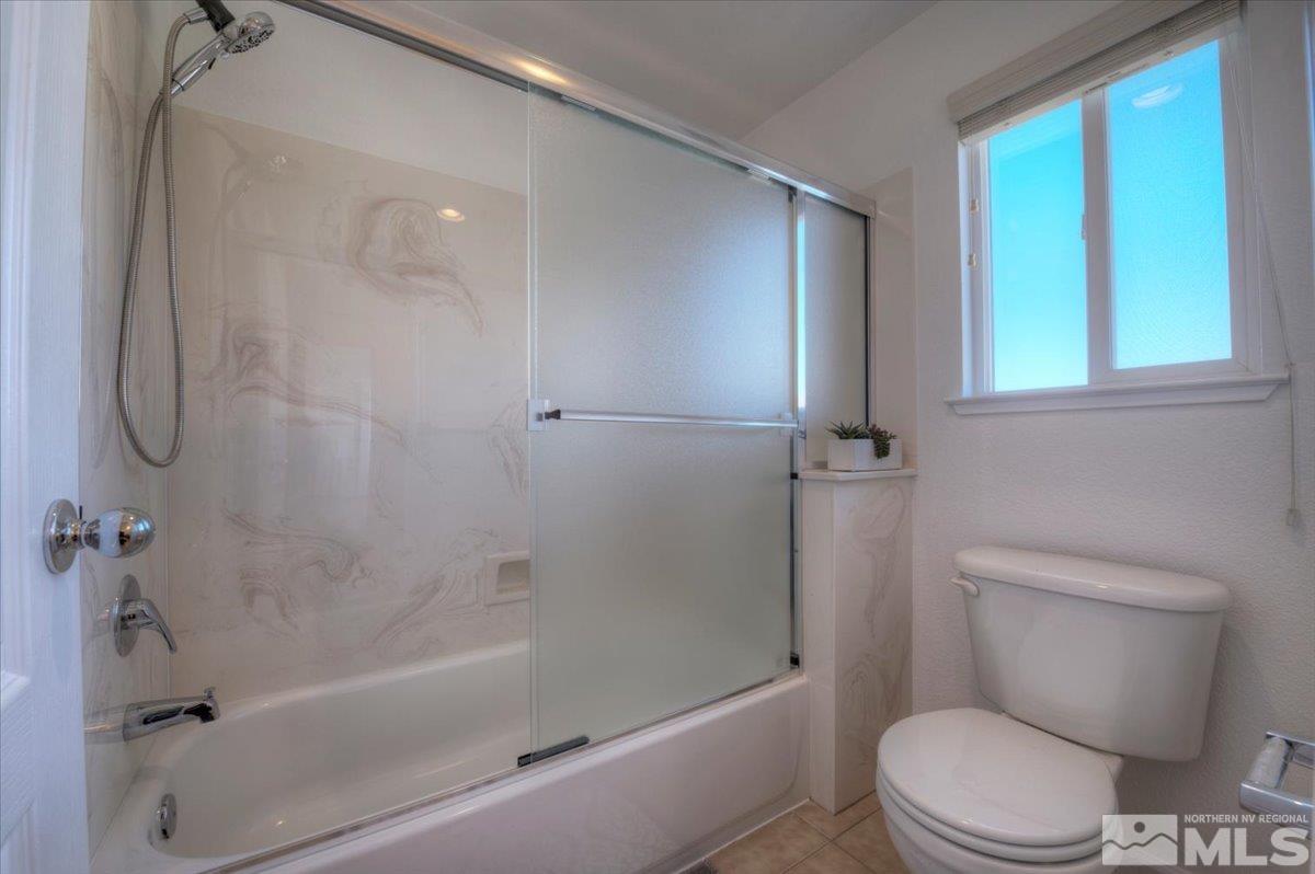 10016 Cascade Falls Drive Reno, NV 89521 - Photo 30 of 40 a white toilet sitting next to a bath tub shower