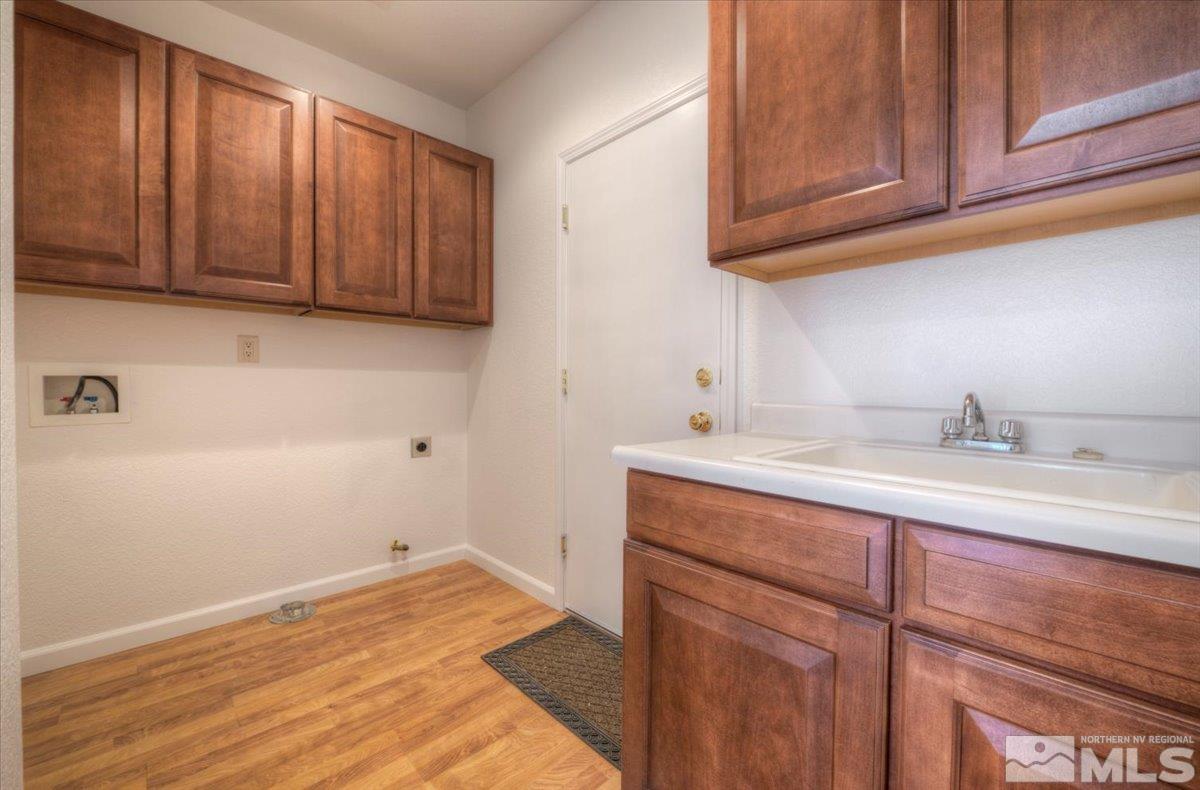10016 Cascade Falls Drive Reno, NV 89521 - Photo 34 of 40 a kitchen with a sink cabinets and a wooden floor