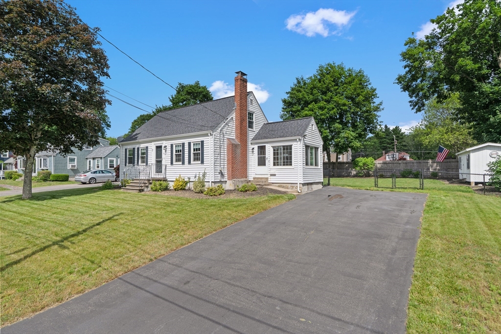 a front view of a house with a yard and trees