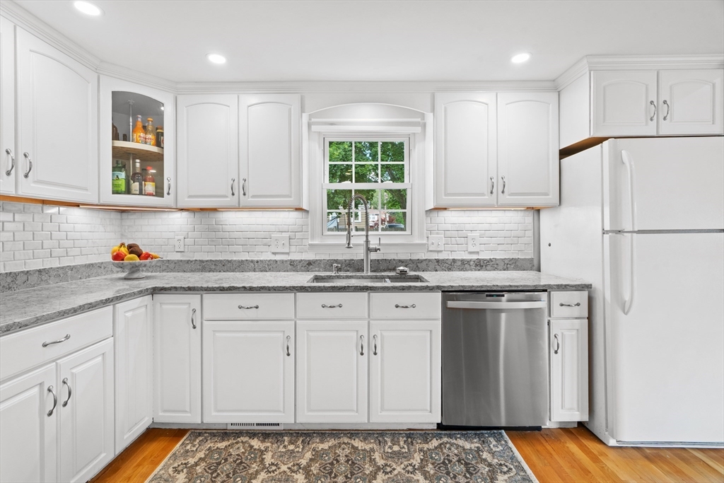 61 Broad Street Walpole, MA 02081 - Photo 4 of 37 a kitchen with granite countertop white cabinets and white appliances