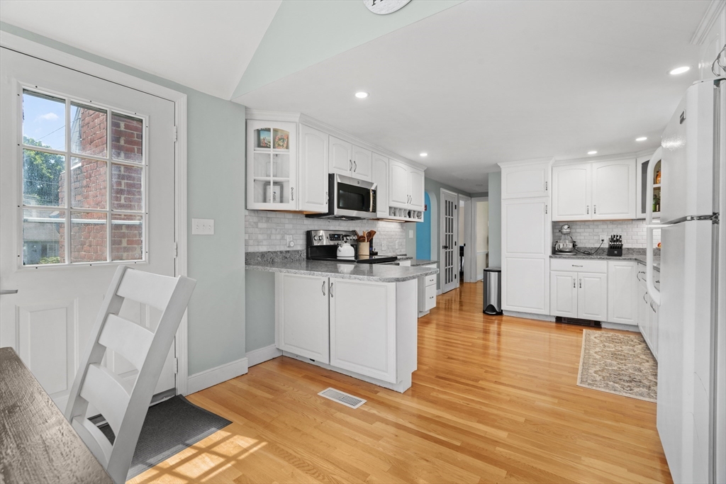 61 Broad Street Walpole, MA 02081 - Photo 9 of 37 a kitchen with white cabinets and stainless steel appliances
