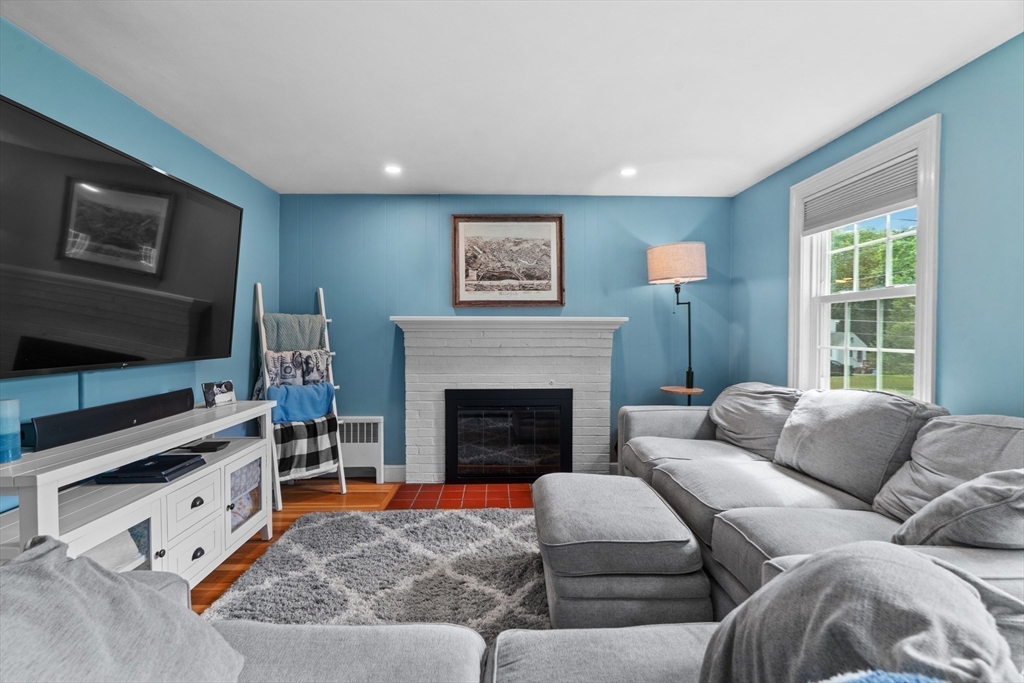 61 Broad Street Walpole, MA 02081 - Photo 10 of 37 a living room with furniture a flat screen tv and a fireplace