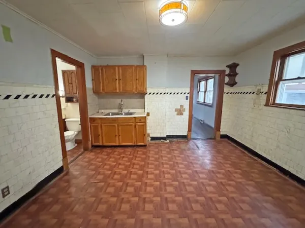 a view of a kitchen with fridge and wooden floor