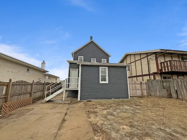 a view of a house with wooden fence