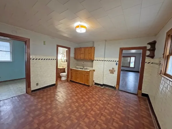 a view of a kitchen with wooden cabinets and refrigerator