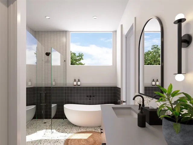 a bathroom with a tub a potted plant and a large window