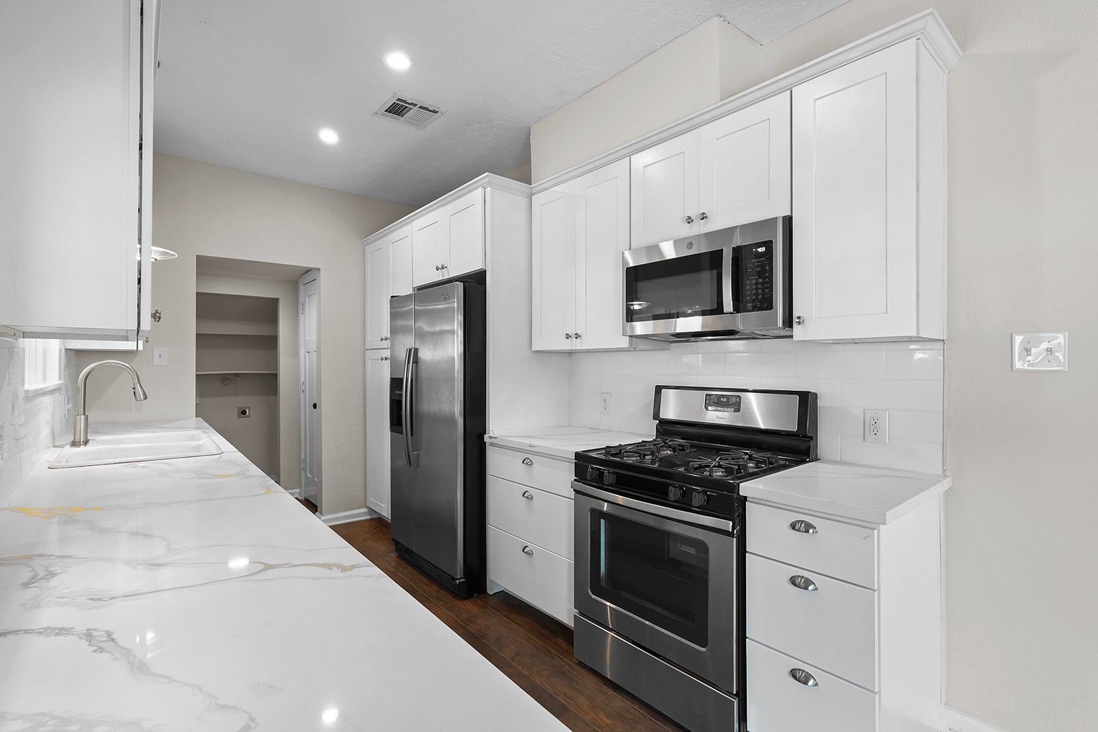 5401 North Capitol Street Houston, TX 77011 - Photo 14 of 34 a kitchen with stainless steel appliances white cabinets white stove a microwave and a refrigerator