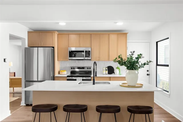 a kitchen with a table chairs refrigerator and microwave