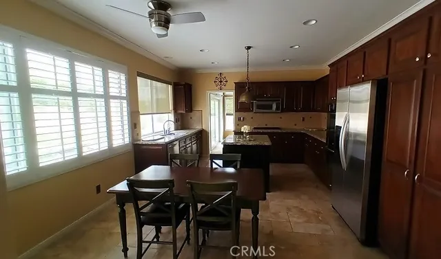a kitchen with a dining table chairs and refrigerator