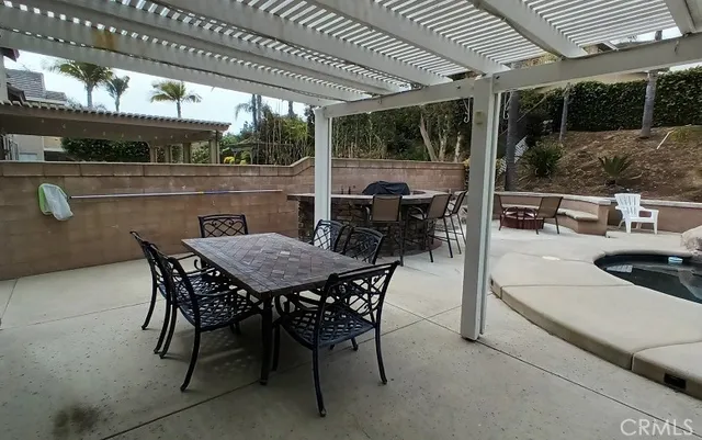 a patio with a table and chairs and potted plants