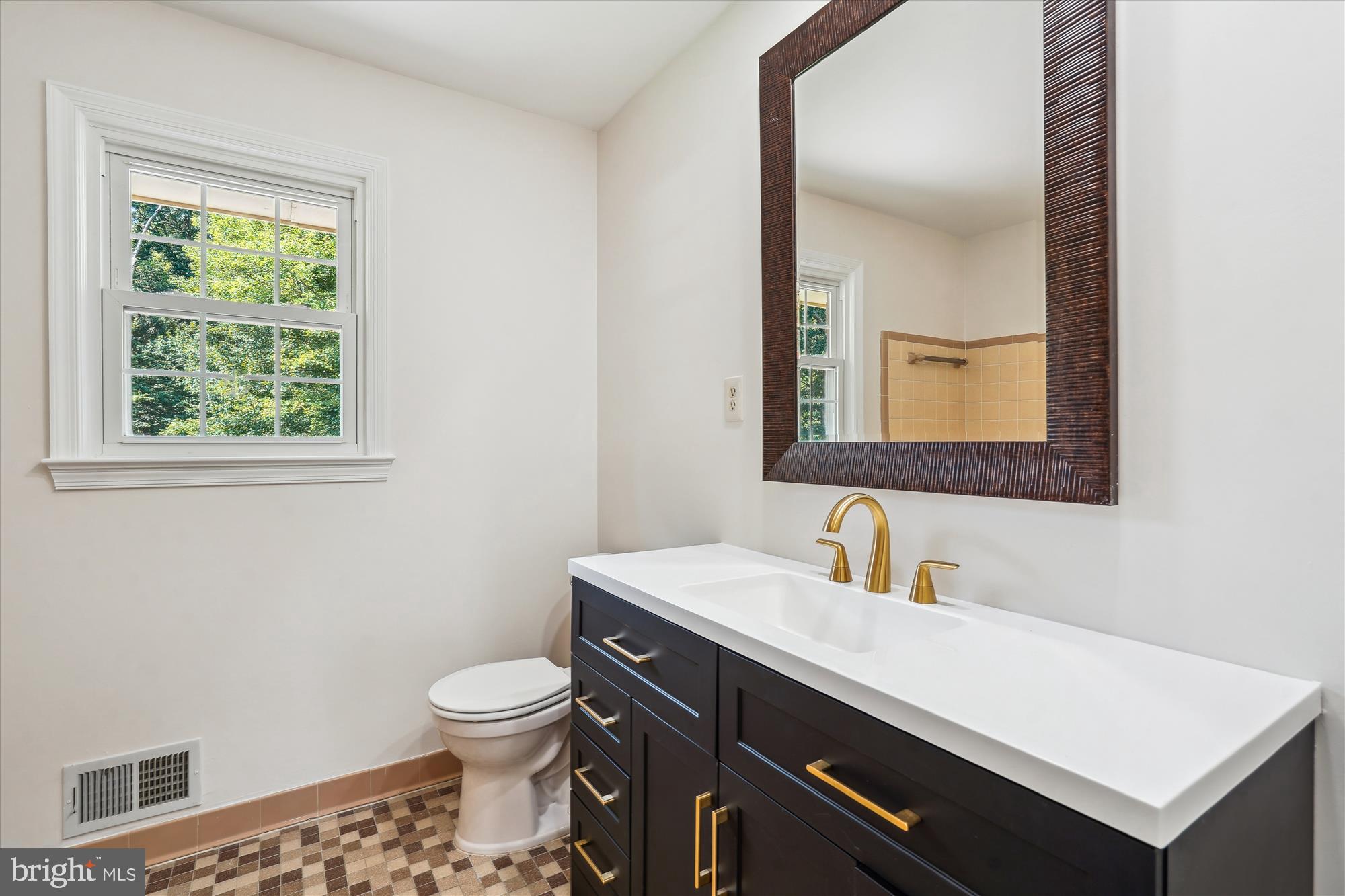 12109 Stirrup Road Reston, VA 20191 - Photo 39 of 52 a bathroom with a toilet a sink a vanity and mirror