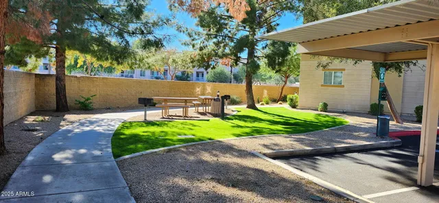 a view of a brick house with a large windows and flower plants