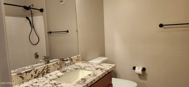 a bathroom with a granite countertop sink toilet and shower
