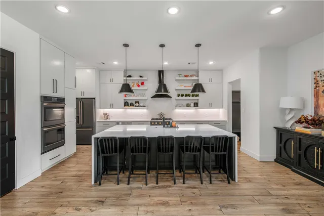 a large kitchen with stainless steel appliances granite countertop a stove and a refrigerator