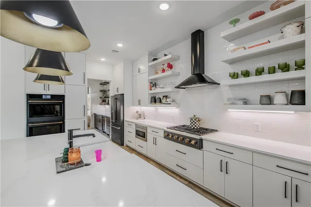 a kitchen with white cabinets and appliances