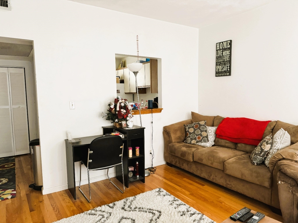 88 Gordon Street, Unit 306 Boston, MA 02135 - Photo 3 of 12 a living room with furniture and a wooden floor