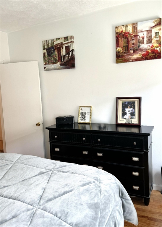 88 Gordon Street, Unit 306 Boston, MA 02135 - Photo 5 of 12 a bedroom with a bed and a mirror