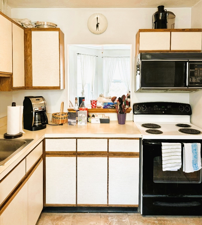 88 Gordon Street, Unit 306 Boston, MA 02135 - Photo 6 of 12 a kitchen with appliances a sink and cabinets
