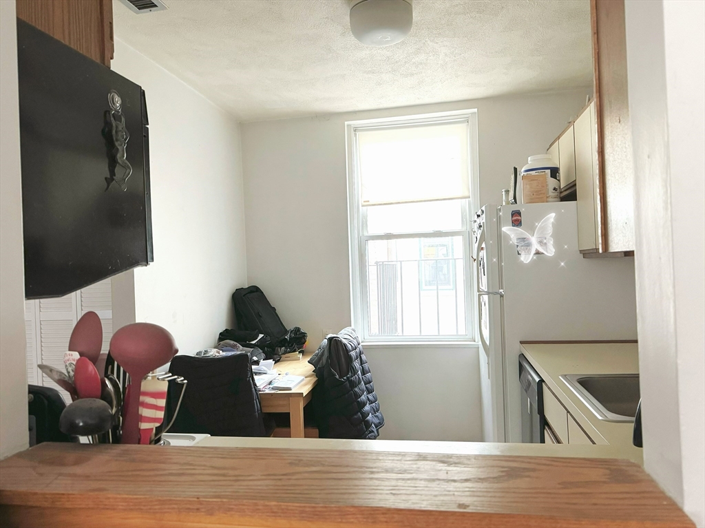 88 Gordon Street, Unit 306 Boston, MA 02135 - Photo 7 of 12 a living room with furniture wooden floor and a flat screen tv