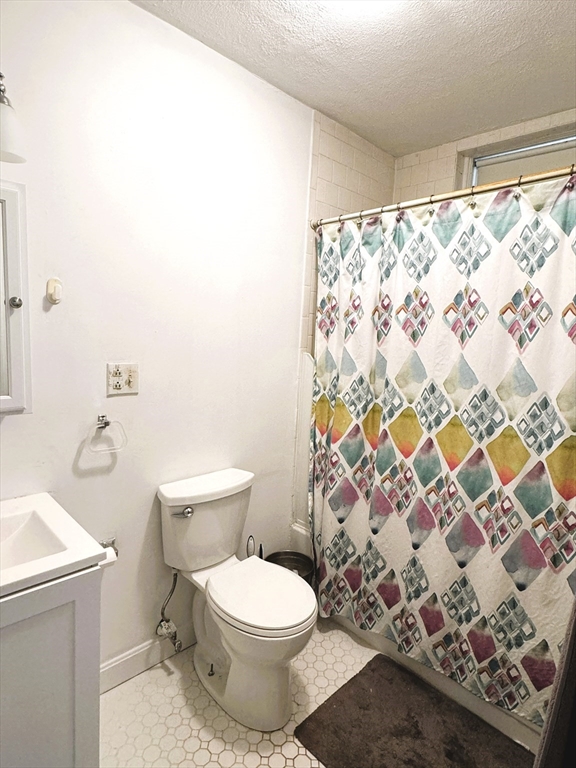 88 Gordon Street, Unit 306 Boston, MA 02135 - Photo 9 of 12 a white toilet sitting next to a shower curtain