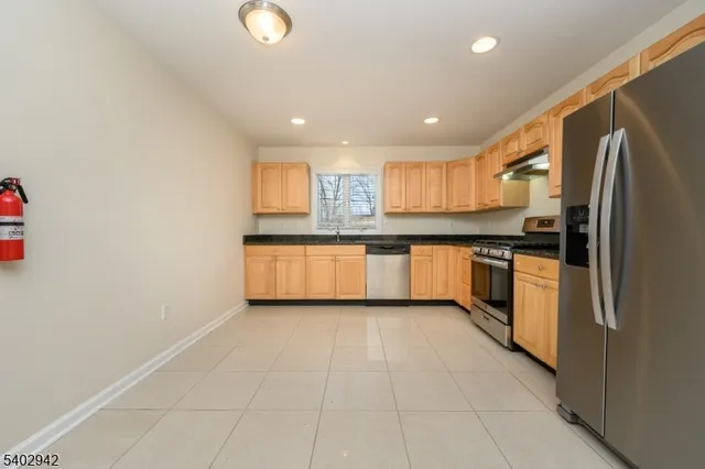 a kitchen with stainless steel appliances granite countertop a stove a sink and a refrigerator