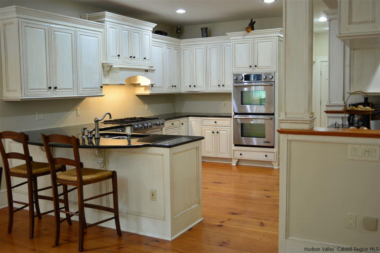 4651 Atwood Road Stone Ridge, NY 12484 - Photo 12 of 31 a kitchen with kitchen island granite countertop a table chairs stove and cabinets