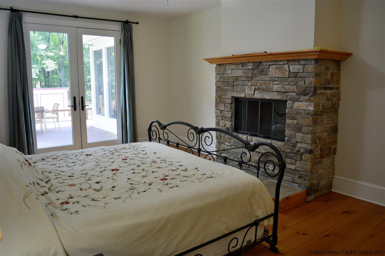4651 Atwood Road Stone Ridge, NY 12484 - Photo 21 of 31 a bedroom with a bed and a fireplace