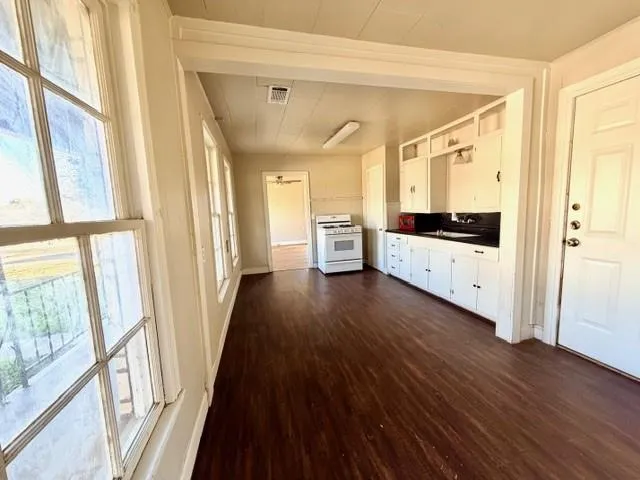 a view of a refrigerator with wooden floor and cabinets
