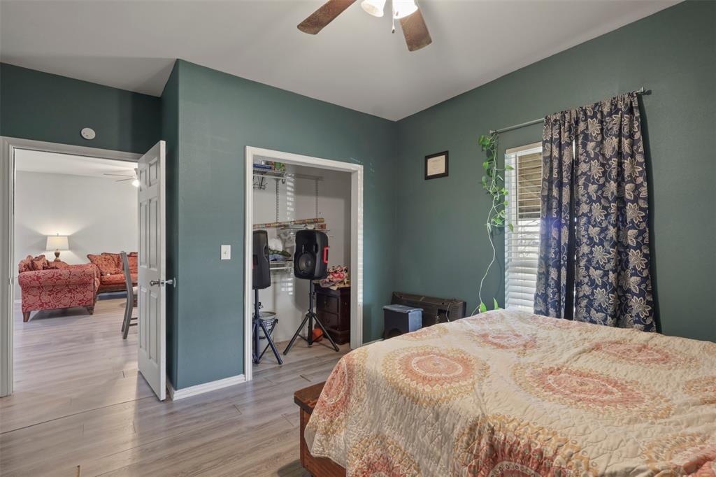 1556 John Wayne Road Kaufman, TX 75142 - Photo 13 of 33 a bedroom with a large bed and a chandelier