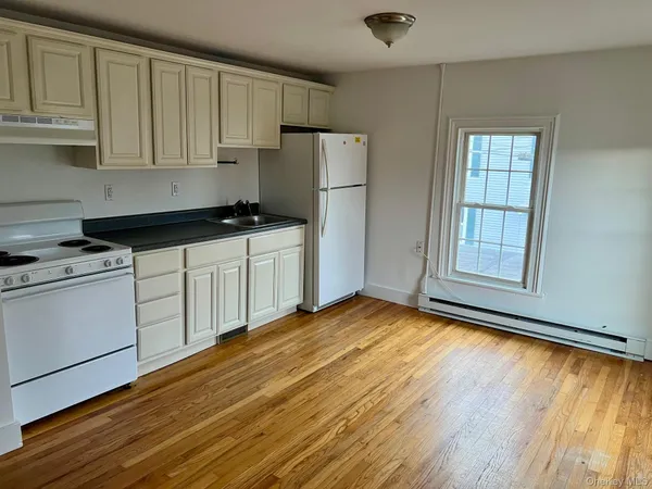 a kitchen with granite countertop wooden cabinets and a stove