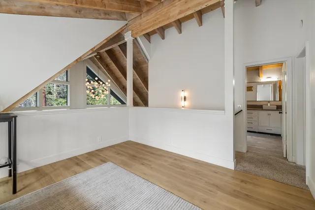 a view of a hallway with wooden floor and staircase