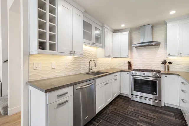 a kitchen with granite countertop a sink stainless steel appliances and cabinets