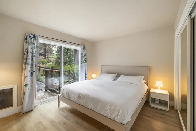 a bedroom with a bed lamp and a large window