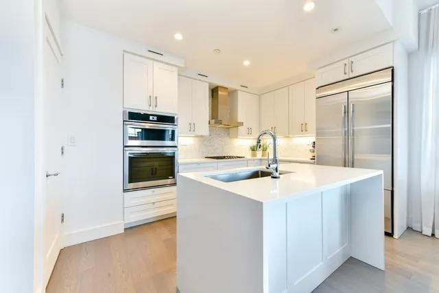 a kitchen with kitchen island sink stove and refrigerator