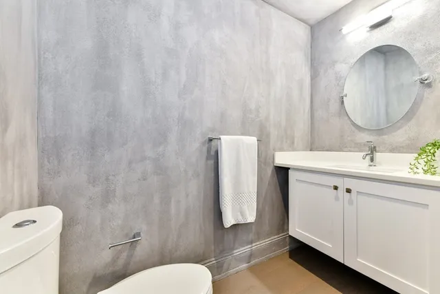 a bathroom with a sink vanity mirror and toilet