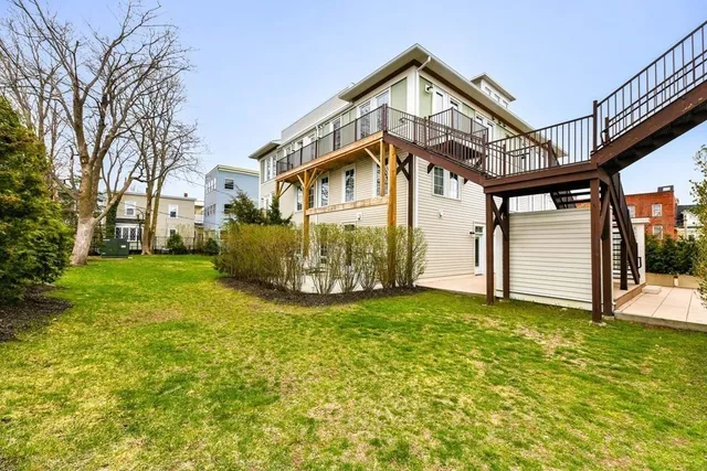 a view of a house with a big yard and large tree