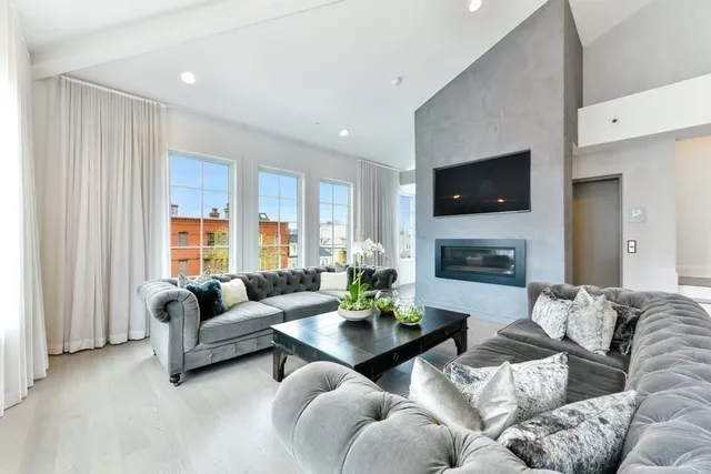 a living room with furniture a fireplace and a flat screen tv