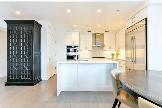 a kitchen with stainless steel appliances granite countertop a refrigerator and a stove top oven