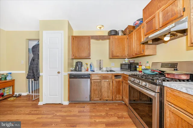 a kitchen with stainless steel appliances granite countertop a stove a sink and a refrigerator
