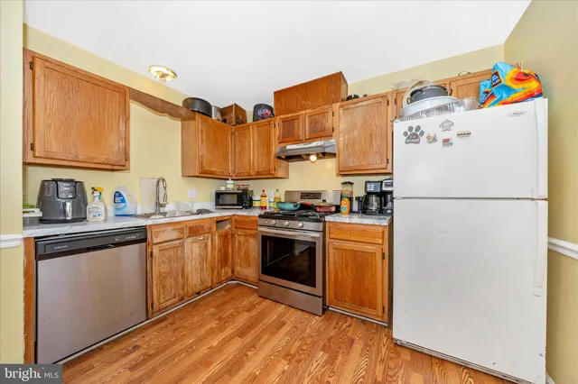 a kitchen with stainless steel appliances granite countertop a refrigerator sink and cabinets