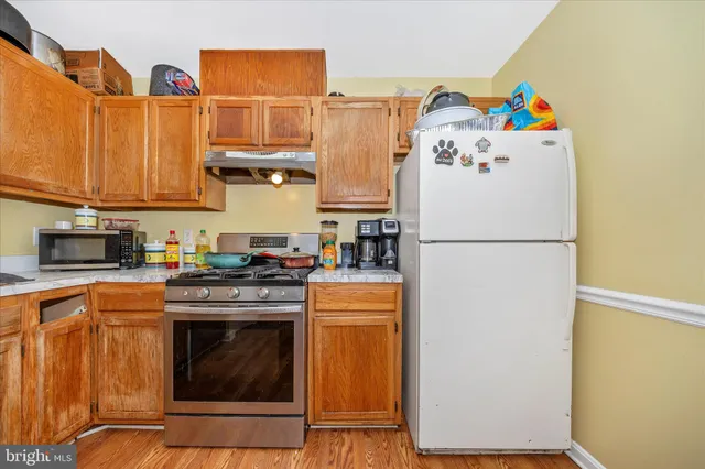 a kitchen with stainless steel appliances granite countertop a refrigerator a stove a sink and dishwasher